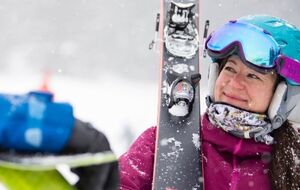 Woman holding skis